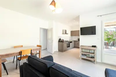 a living room with a dining room table and a kitchen at La Belle-Hélène - Proche plage, 30 min d'ajaccio in Albitreccia