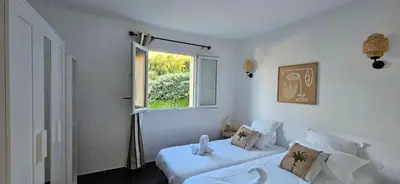 a white room with two beds and a window at T2 Résidence Dolce & Vita C4 vue mer et piscine in Propriano