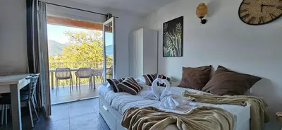 a living room with a couch and a clock on the wall at T2 Résidence Dolce & Vita C4 vue mer et piscine in Propriano