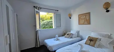 a bedroom with two beds and a window at T2 Résidence Dolce & Vita C4 vue mer et piscine in Propriano