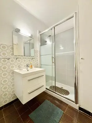 a bathroom with a white sink and a shower at A 20min d AJACCIO, Grand studio 3 personnes - pieds dans l'eau - accès direct plage - vue mer exceptionnelle in Casaglione