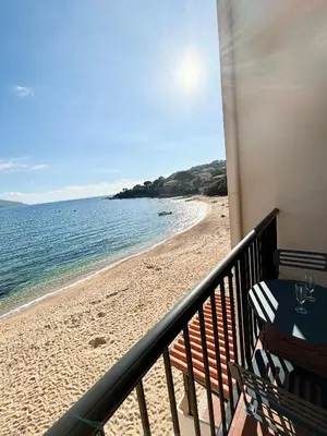 a balcony with a view of the beach at A 20min d AJACCIO, Grand studio 3 personnes - pieds dans l'eau - accès direct plage - vue mer exceptionnelle in Casaglione