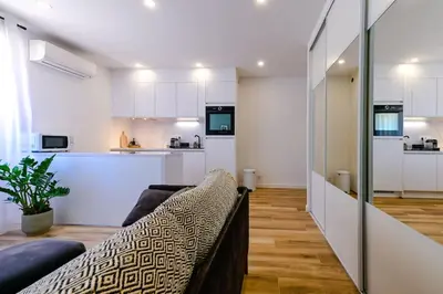 a living room with a couch and a kitchen at Studio Cosy à Ajaccio in Ajaccio