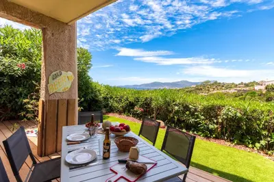 a white table and chairs on a patio with a view at Libertà - Appt à porticcio climatisé proche plage in Grosseto-Prugna