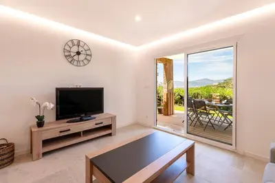 a living room with a tv and a table at Libertà - Appt à porticcio climatisé proche plage in Grosseto-Prugna