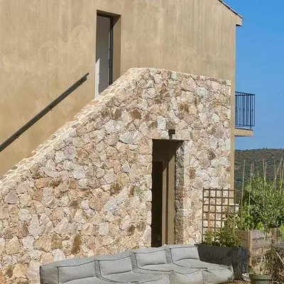 a stone building with a couch in front of it at Bella Vita in Calenzana