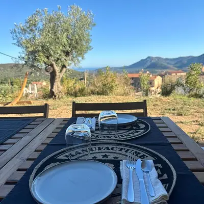 a table with plates and silverware on top at Bella Vita in Calenzana