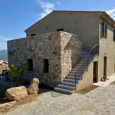 a stone building with stairs in front of it at Bella Vita in Calenzana