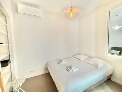 a small white room with a bed and a window at Appartement studio cours napoleon Ajaccio in Ajaccio