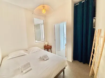 a bedroom with a white bed and a window at Appartement studio cours napoleon Ajaccio in Ajaccio