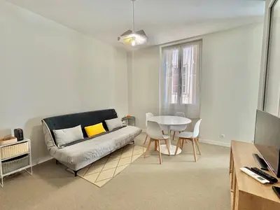 a living room with a couch and a table at Appartement studio cours napoleon Ajaccio in Ajaccio