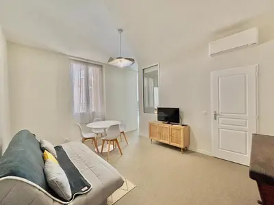 a living room with a couch and a table and a television at Appartement studio cours napoleon Ajaccio in Ajaccio