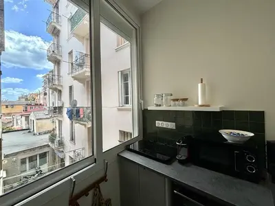 a kitchen with a window and a microwave on a counter at Appartement studio cours napoleon Ajaccio in Ajaccio