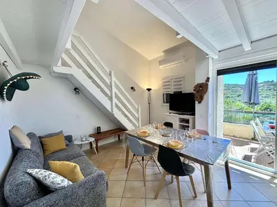 a living room with a couch and a dining room table at Appartement 105 résidence Terra Bella 1 Porticcio in Porticcio