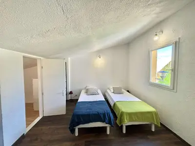 two beds in a room with a window at Appartement 105 résidence Terra Bella 1 Porticcio in Porticcio
