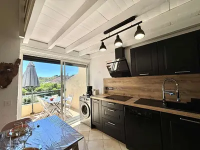 a kitchen with a sink and a table and a window at Appartement 105 résidence Terra Bella 1 Porticcio in Porticcio