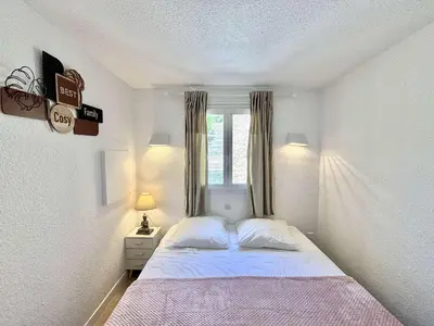 a white bedroom with a bed and a window at Appartement 105 résidence Terra Bella 1 Porticcio in Porticcio