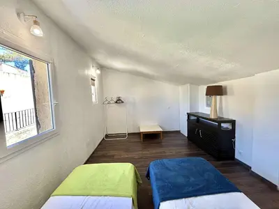 a room with two beds and a window at Appartement 105 résidence Terra Bella 1 Porticcio in Porticcio