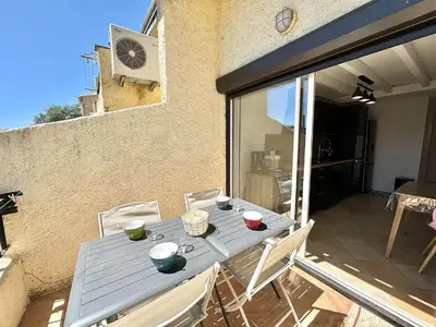 a table and chairs on the balcony of a house at Appartement 105 résidence Terra Bella 1 Porticcio in Porticcio