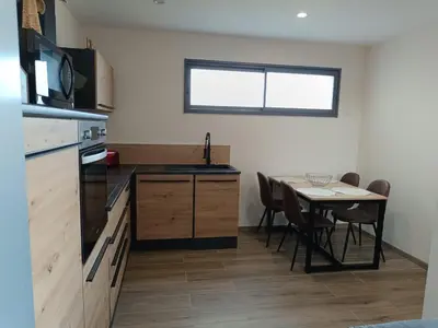a kitchen with a table and a table and chairs at Dume et Coco F2 55 M2 Vue mer in Taglio-Isolaccio