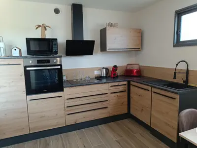 a kitchen with wooden cabinets and a stove top oven at Dume et Coco F2 55 M2 Vue mer in Taglio-Isolaccio