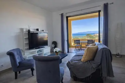 a living room with a tv and a couch and chairs at T3 de standing Vigna Majo vue mer imprenable in Propriano