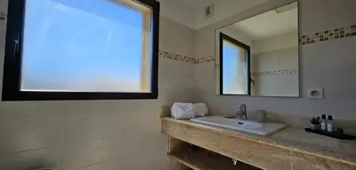 a bathroom with a sink and a mirror at T3 de standing Vigna Majo vue mer imprenable in Propriano