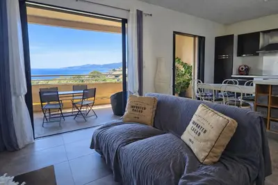 a living room with a couch and a view of the ocean at T3 de standing Vigna Majo vue mer imprenable in Propriano