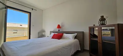a bedroom with a bed and a large window at T3 de standing Vigna Majo vue mer imprenable in Propriano