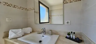 a bathroom with a sink and a mirror at T3 de standing Vigna Majo vue mer imprenable in Propriano