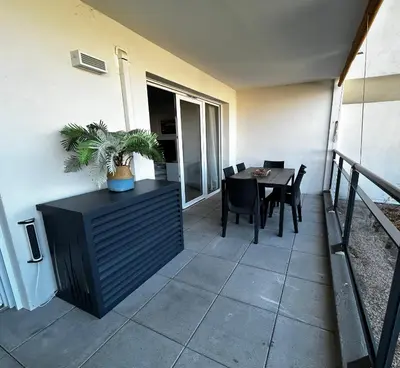 a balcony with a table and a dining room at Appartement Rocade in Ajaccio