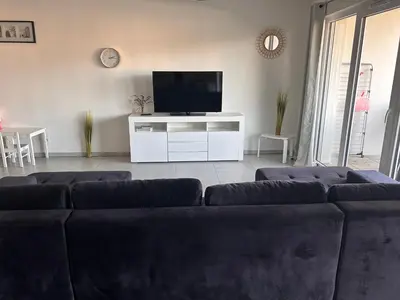 a living room with a couch and a flat screen tv at Appartement Rocade in Ajaccio