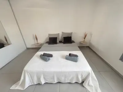a room with a white table with two pillows on it at Appartement Rocade in Ajaccio