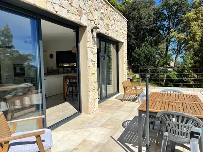 a patio with glass doors and a table and chairs at Casa di Cortanni in Castellare-di-Casinca