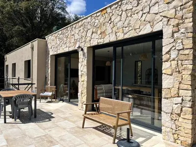 a stone building with a patio with a table and chairs at Casa di Cortanni in Castellare-di-Casinca