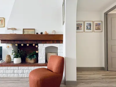 a living room with a chair and a fireplace at Front de mer Beau T3 climatisé Balcon Parking Ajaccio in Ajaccio