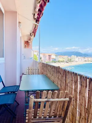 a table and chairs on a balcony with a view of the ocean at Front de mer Beau T3 climatisé Balcon Parking Ajaccio in Ajaccio
