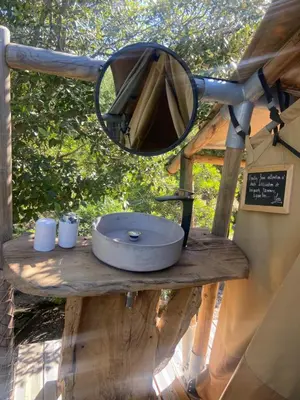 a mirror on top of a wooden table with a sink at A Malgrana - Tente lodge hébergement insolite in Coti-Chiavari