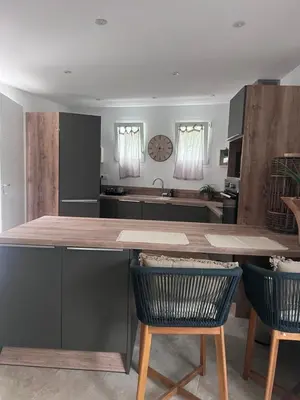 a kitchen with a large wooden table and two chairs at Appartement casa Di l Ortu in Ajaccio