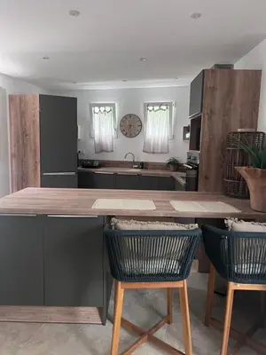 a kitchen with a large counter and two chairs at Appartement casa Di l Ortu in Ajaccio