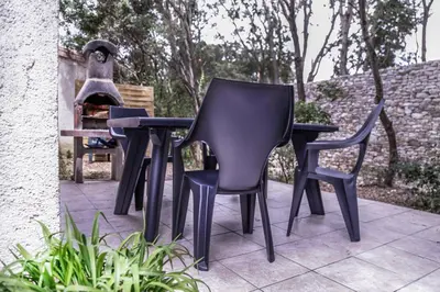 three black chairs and a table and a bird feeder at Perla Di Macchia in Bonifacio