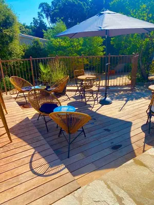 a patio with tables and chairs and an umbrella at Perla Di Macchia in Bonifacio