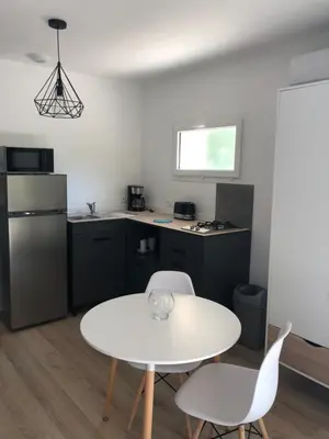 a small kitchen with a white table and chairs at Perla Di Macchia in Bonifacio