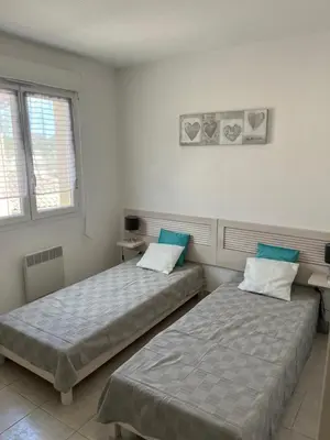 two beds sitting next to each other in a room at Corse villa T3 piscine in Santa-Maria-Poggio
