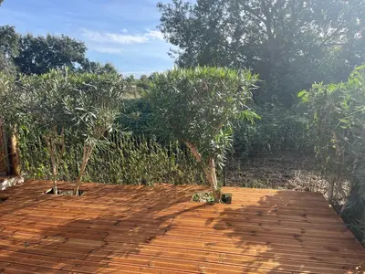 a wooden deck with two trees on top of it at Corse villa T3 piscine in Santa-Maria-Poggio
