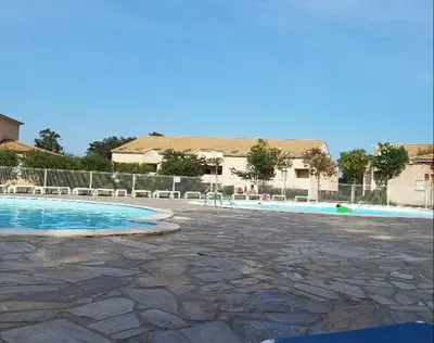 an empty swimming pool with a building in the background at Corse villa T3 piscine in Santa-Maria-Poggio