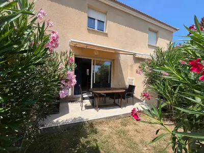 a house with a table and chairs and flowers at Corse villa T3 piscine in Santa-Maria-Poggio