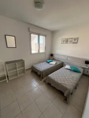 a room with two beds and a window at Corse villa T3 piscine in Santa-Maria-Poggio