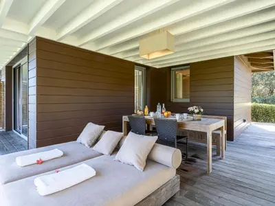 a patio with a couch and a table with a dining room at Apartment Le Trois du Petit Sperone by Interhome in Bonifacio