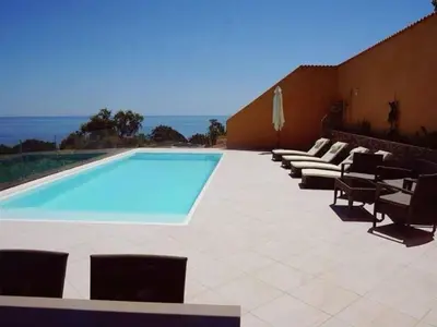 a swimming pool with some chairs and a group ofitures at Villa Villa Orizonte by Interhome in Favone